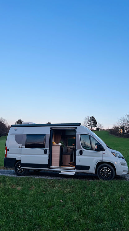 Camper Bruno, ein moderner 6-Meter-Wohnmobil mit großem Bett, Verdunkelungsrollos, externer Klimaanlage und voll ausgestatteter Küche, ideal für Roadtrips und längere Reisen